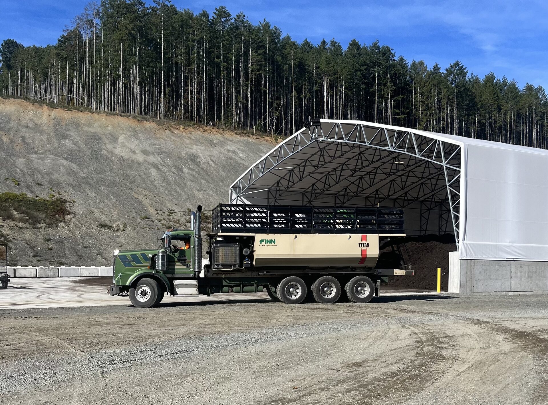 Raincoast-group hydroseeding truck loading under cover at a Vancouver Island work site